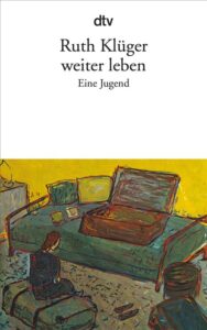Ein junges Mädchen sitzt auf einem Koffer vor einem Bett.