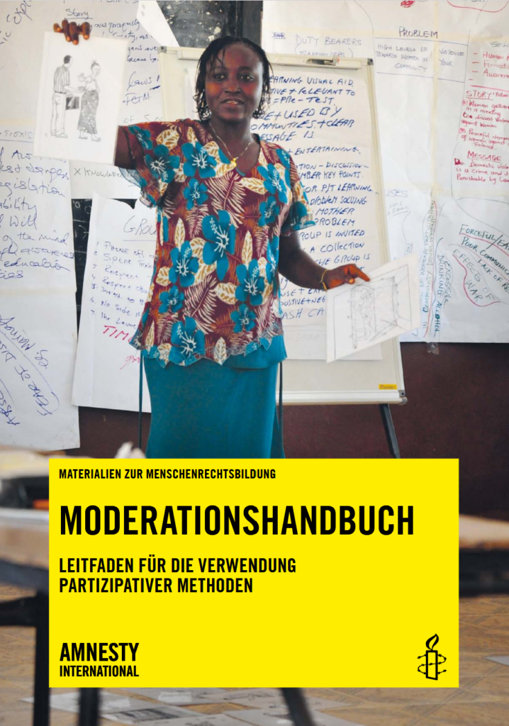 Eine Frau gibt einen Workshop und hält eine Zeichnung hoch.