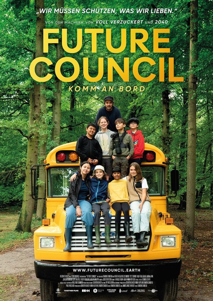 Auf einem gelben Schulbus im Wald sitzen acht Kinder und ein Erwachsener.